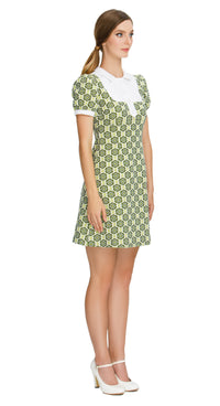 Fitted sixties style, shades of green floral,  a-line dress; a versatile piece suitable for both work and play. This dress features a charming floral pattern in various shades of green, exuding a delightful retro vibe. The style features a white bib offset by a 4-button-detailed tab, slightly puffed short sleeves, and functional side pockets, adding a touch of timeless elegance and practicality to the ensemble.