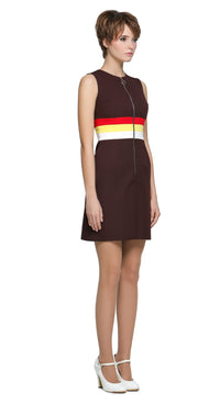 A nod to the swagger of Britain in the nineties. A playful and cool retro sporty-inspired sixties silhouette with a sleeveless design, a front pleat and retro circle zipper pull front closure. Colour band details around the waist add an extra pop of charm. Worn down with your favorite kicks and a cardigan or dressed to kill with heels. A style that’s as fitting for a music festival as it is for your bestie’s big do. Available as shown here in classic brown with red, yellow, and white striping, or in alterna