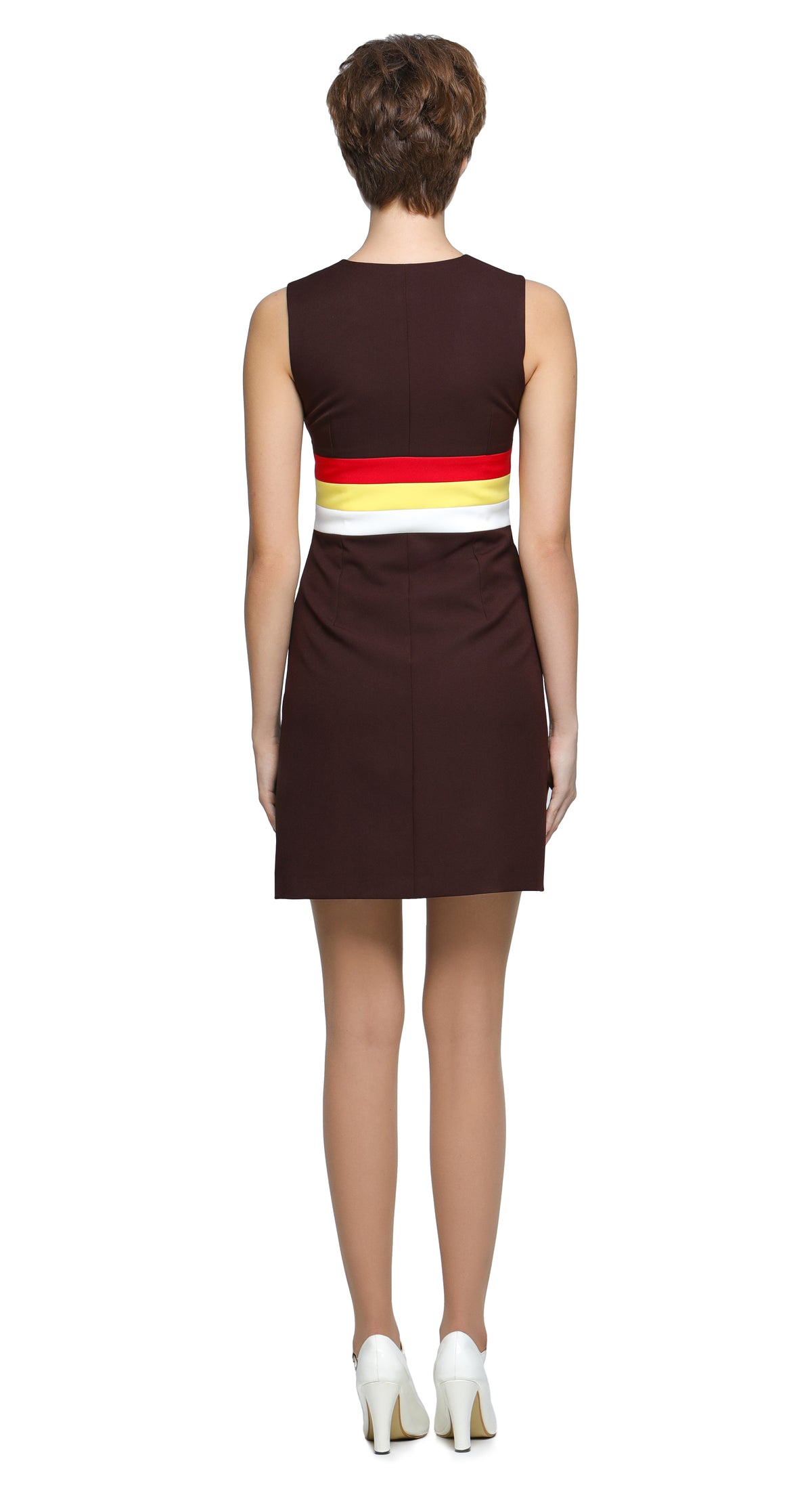 A nod to the swagger of Britain in the nineties. A playful and cool retro sporty-inspired sixties silhouette with a sleeveless design, a front pleat and retro circle zipper pull front closure. Colour band details around the waist add an extra pop of charm. Worn down with your favorite kicks and a cardigan or dressed to kill with heels. A style that’s as fitting for a music festival as it is for your bestie’s big do. Available as shown here in classic brown with red, yellow, and white striping, or in alterna