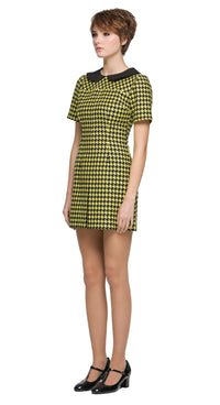 Autumn, slightly A-line yellow/black houndstooth, short-sleeve dress with a classic black Peter Pan collar and front pleat. 
Shown here with short sleeves, though alternative sleeve and hem lengths are available. A lively retake on a classic houndstooth look, enhanced by uplifting colors. Made from a French heritage mill fabric.