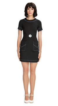 Embrace elegance with our charming mod, 60s style, Little Black Dress, featuring short sleeves (also available in ¾”). This dress boasts a rounded neckline with flattering topstitch neck detailing, extending throughout the piece, as well as deep skirt pockets and solo white flower waist level detailing.