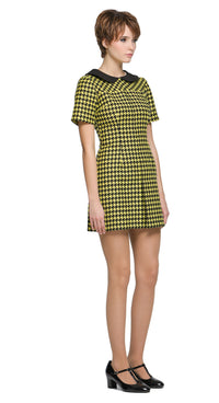 Autumn, slightly A-line yellow/black houndstooth, short-sleeve dress with a classic black Peter Pan collar and front pleat. 
Shown here with short sleeves, though alternative sleeve and hem lengths are available. A lively retake on a classic houndstooth look, enhanced by uplifting colors. Made from a French heritage mill fabric.