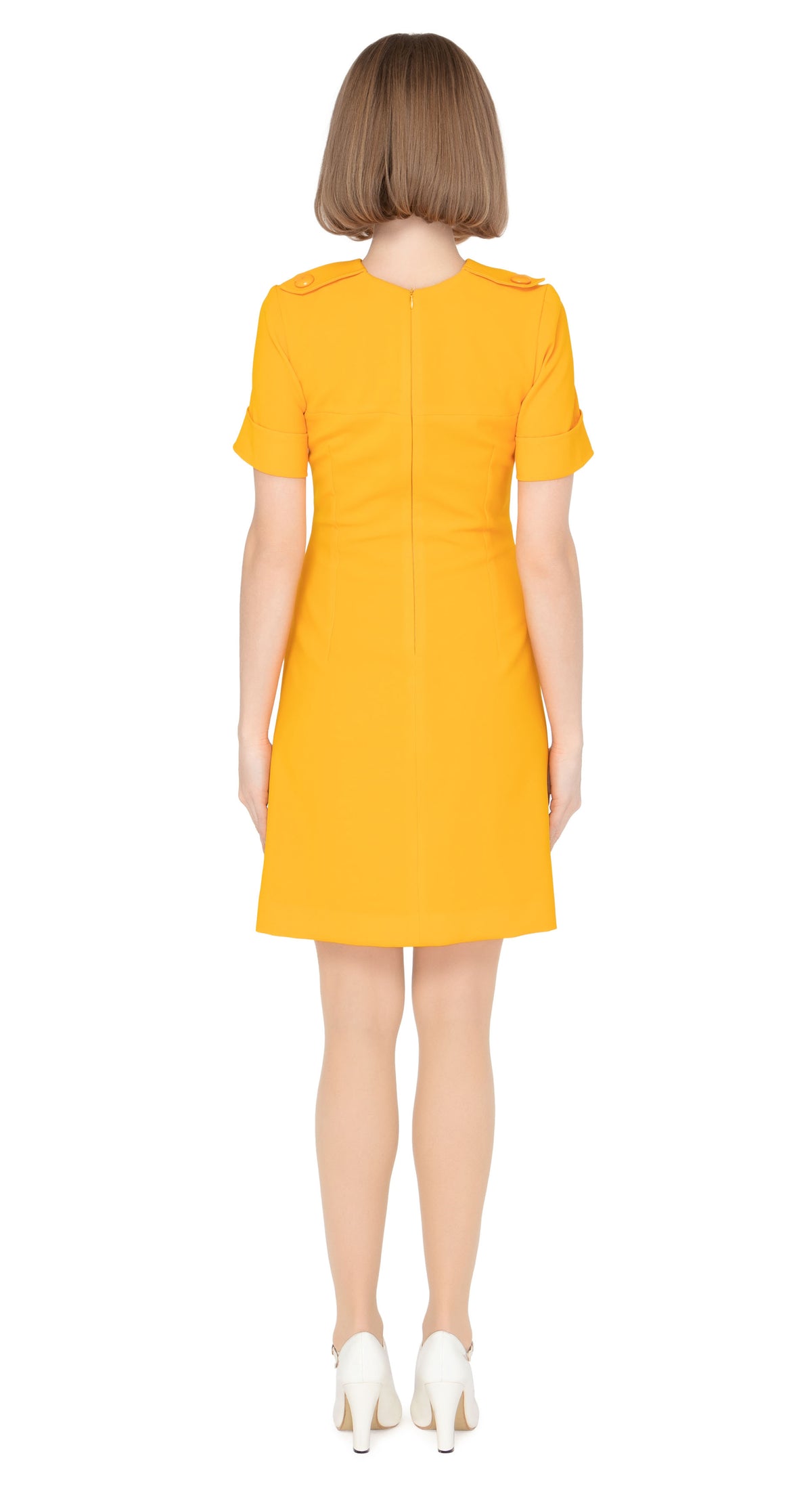 Fitted sixties cut dress with decorative five button placket, button shoulder tabs, short sleeves and functioning button tab essentials pockets with an attractive skirt pleat & immediately striking detailing throughout the bold bright orange Spanish fabric. An entrance maker for all functions, dressed to the nines with heels or casual and cool with kicks or flats.  Please choose bespoke to alternate sleeve or hem length.  Available in various colours. Please contact us for more information.