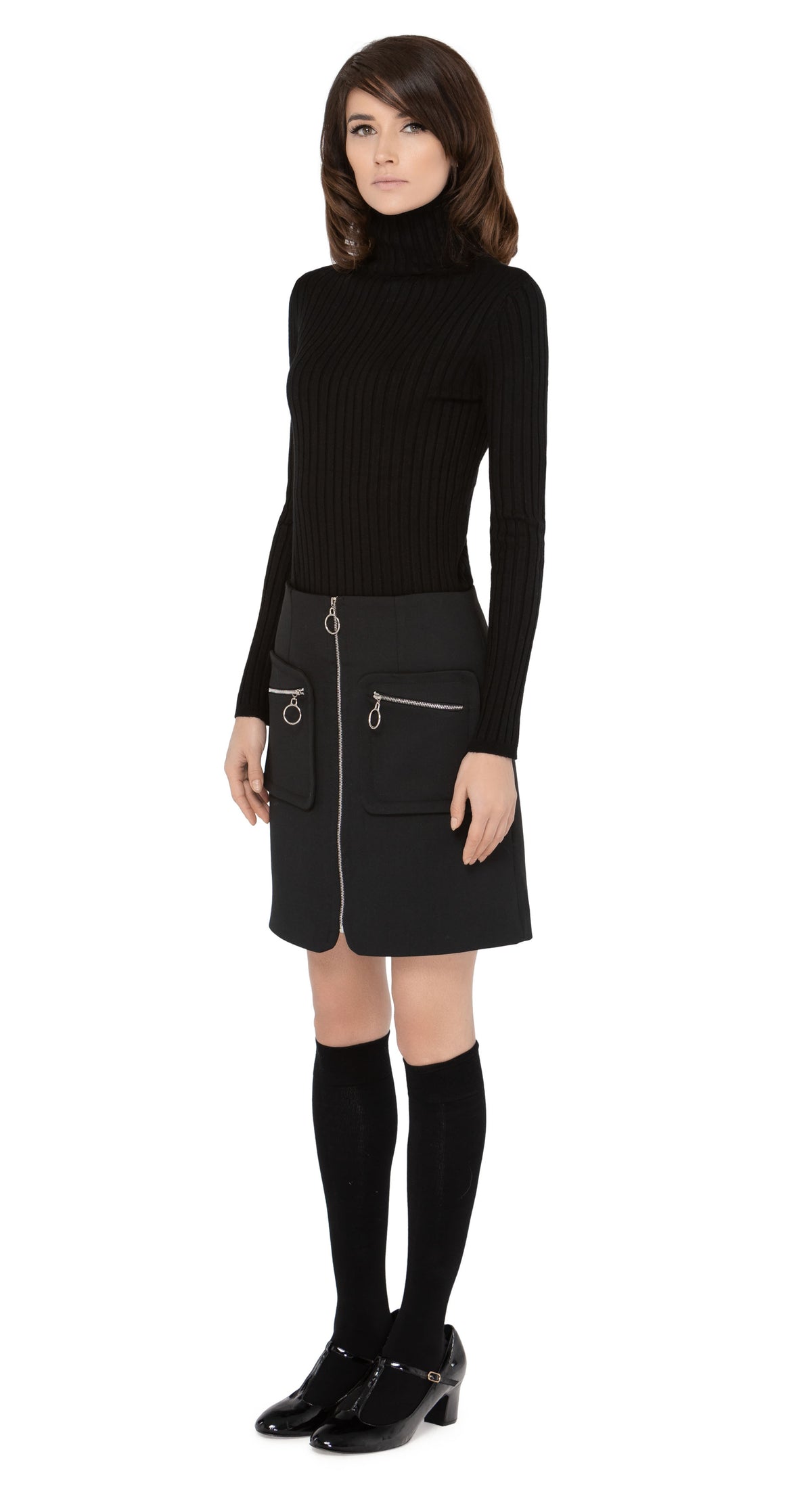 Marmalade zip up skirt in a classic black Italian fabric with functioning zip essentials pockets, retro loop zip pulls and front loop zip closure.  Shown here, worn with a classic ribbed black turtleneck and knee highs which are sold separately. Please enquire to shop the full look. Also available in emerald green.  Pairs perfectly as intended with our 1960s Style Coat with Detachable Faux Fur, to create an impacting set.