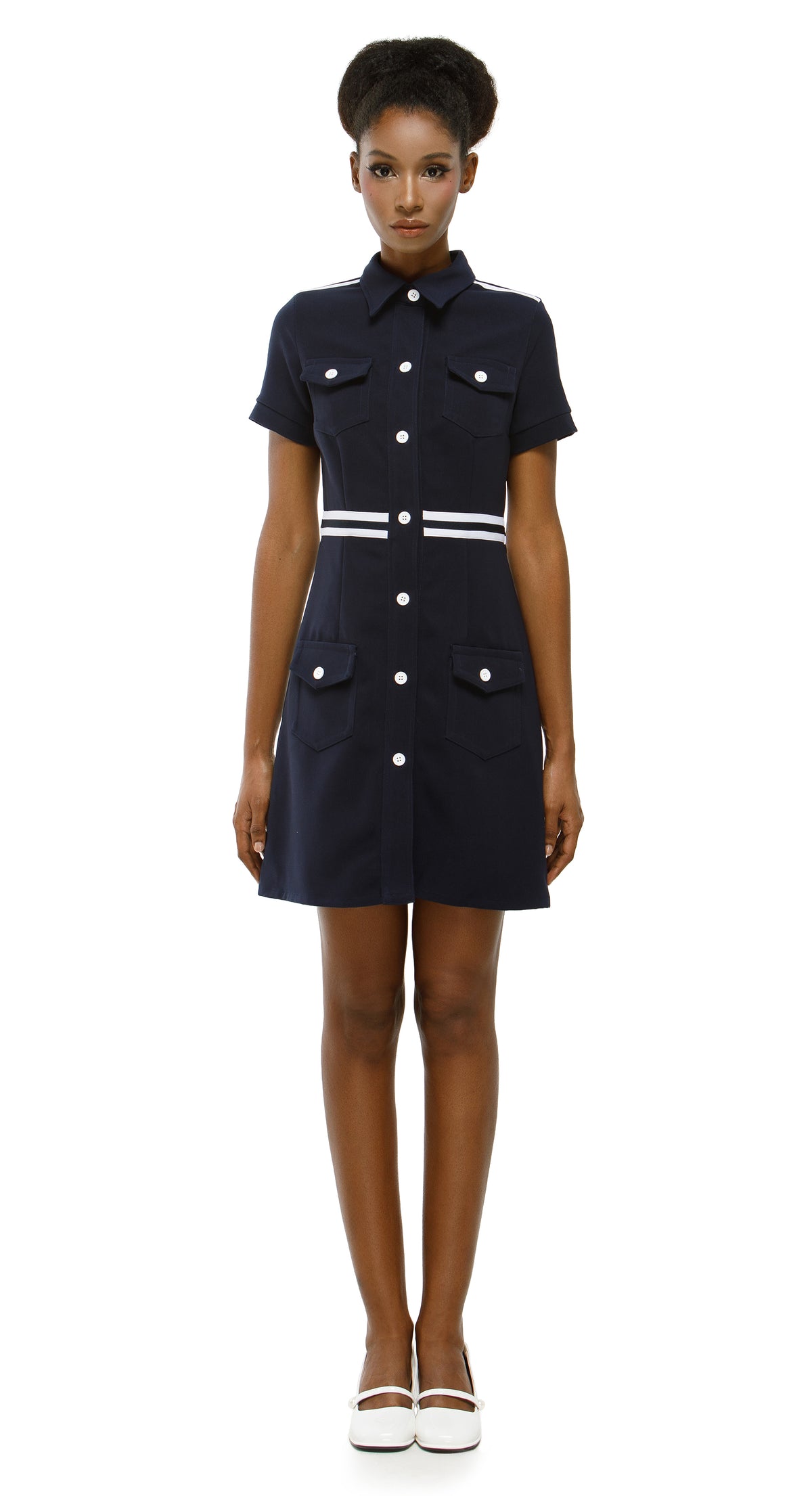 Woman wearing a navy dress with white buttons on a white background