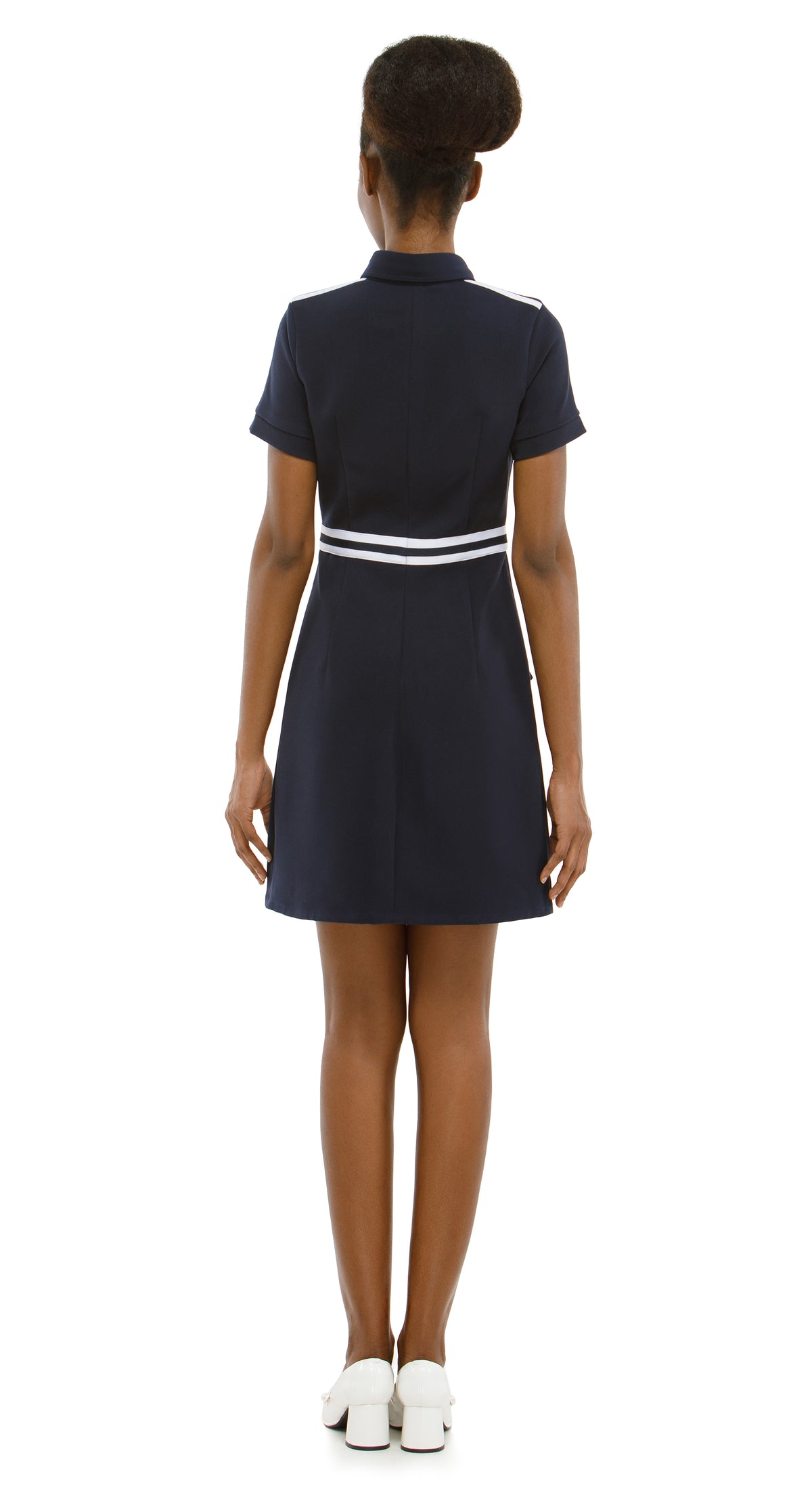 Woman wearing a navy dress with a white stripe on a white background