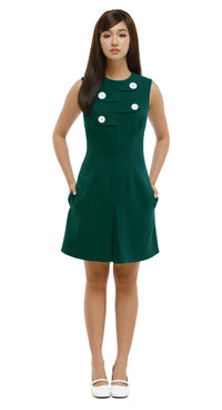 Green dress with white buttons worn by a model on a white background