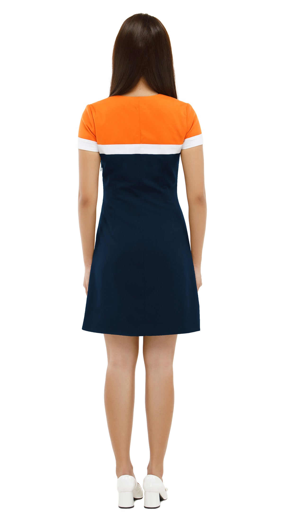 Woman wearing a dress with orange top and navy skirt on a white background