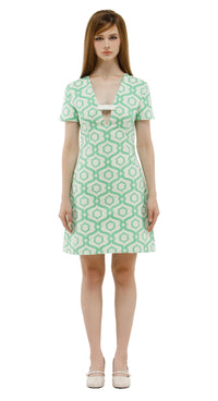 Woman wearing a green patterned dress on a white background