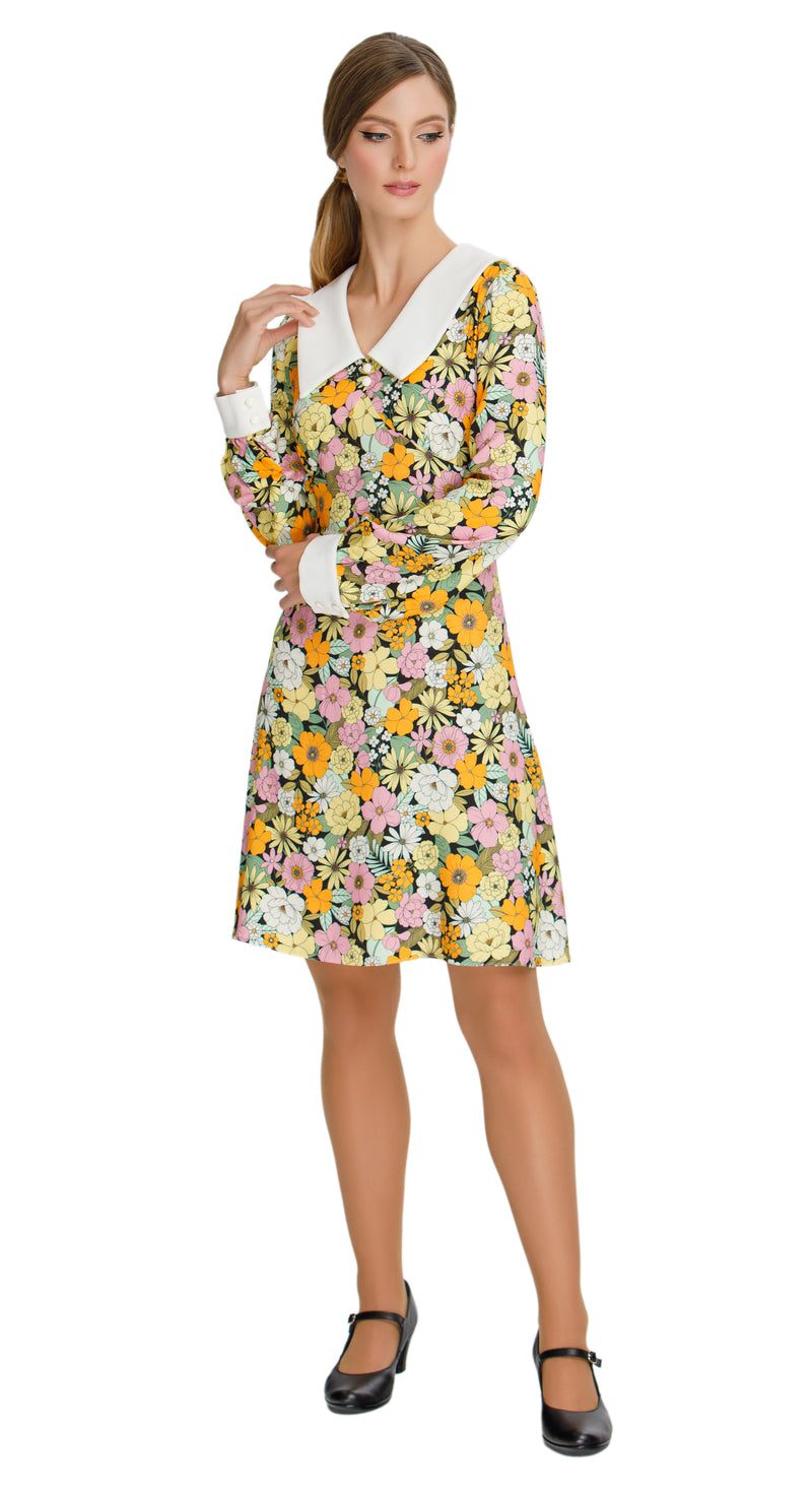 Our Autumn Floral Shift Dress; a versatile and charming addition to your wardrobe. This dress boasts a vibrant floral pattern in tones that evoke the essence of autumn, making it the perfect choice for both work and leisure. The oversized collar and white cuffed long sleeves with white button detailing add a touch of sophistication to the piece.
