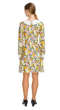 Our Autumn Floral Shift Dress; a versatile and charming addition to your wardrobe. This dress boasts a vibrant floral pattern in tones that evoke the essence of autumn, making it the perfect choice for both work and leisure. The oversized collar and white cuffed long sleeves with white button detailing add a touch of sophistication to the piece.