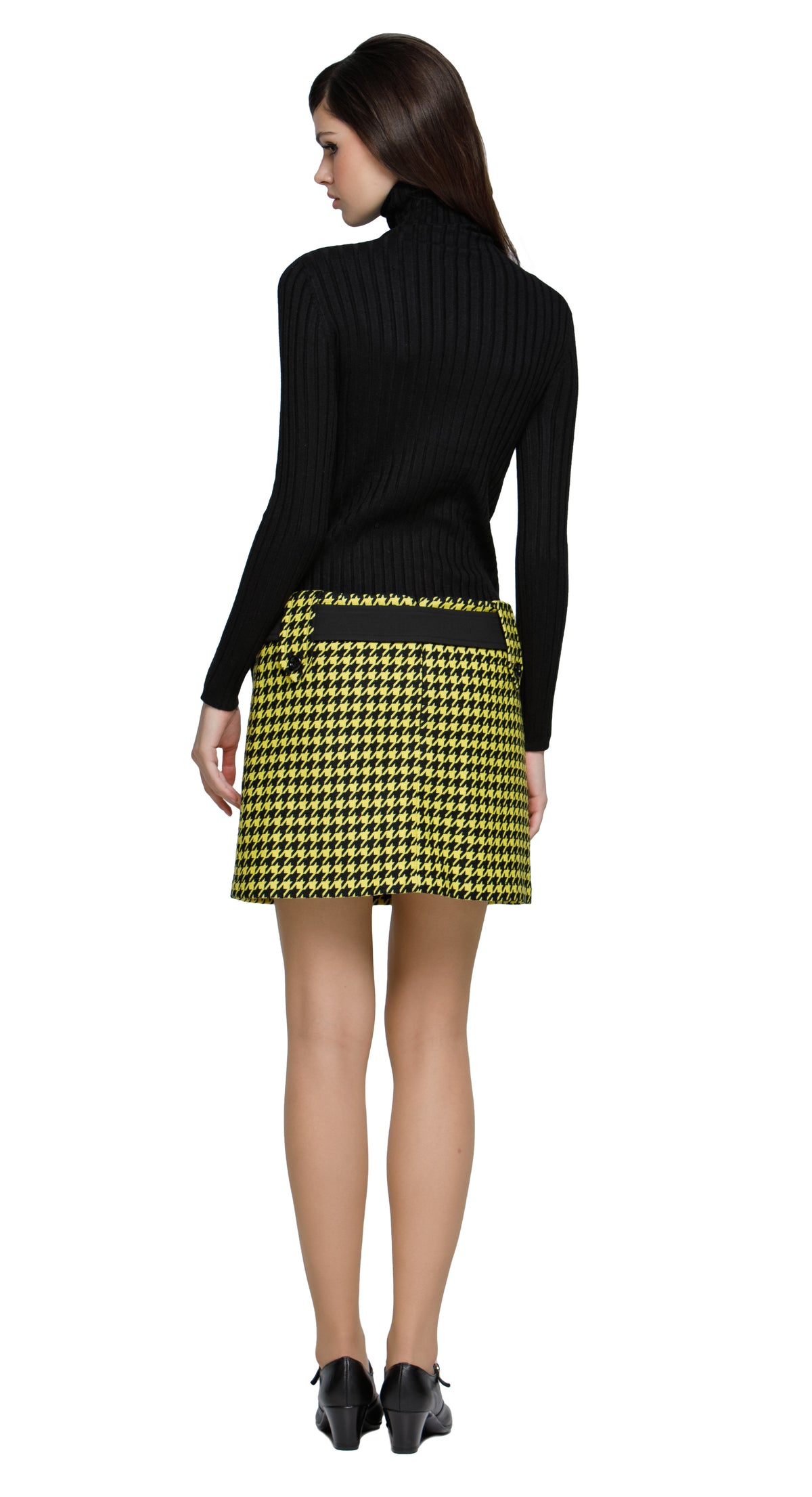 Autumn, yellow/black houndstooth mini skirt featuring large button-down belt loops and an oversized black buckled belt. A playful twist on a classic pattern, this skirt brings bold, contrasting details to the forefront. Perfect for pairing with a simple top or layered for a more dynamic look. Available in alternative lengths for added versatility. Made from heritage French mill fabric.