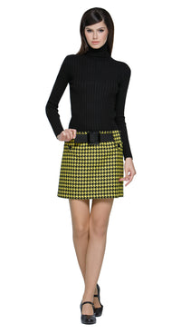 Autumn, yellow/black houndstooth mini skirt featuring large button-down belt loops and an oversized black buckled belt. A playful twist on a classic pattern, this skirt brings bold, contrasting details to the forefront. Perfect for pairing with a simple top or layered for a more dynamic look. Available in alternative lengths for added versatility. Made from heritage French mill fabric.