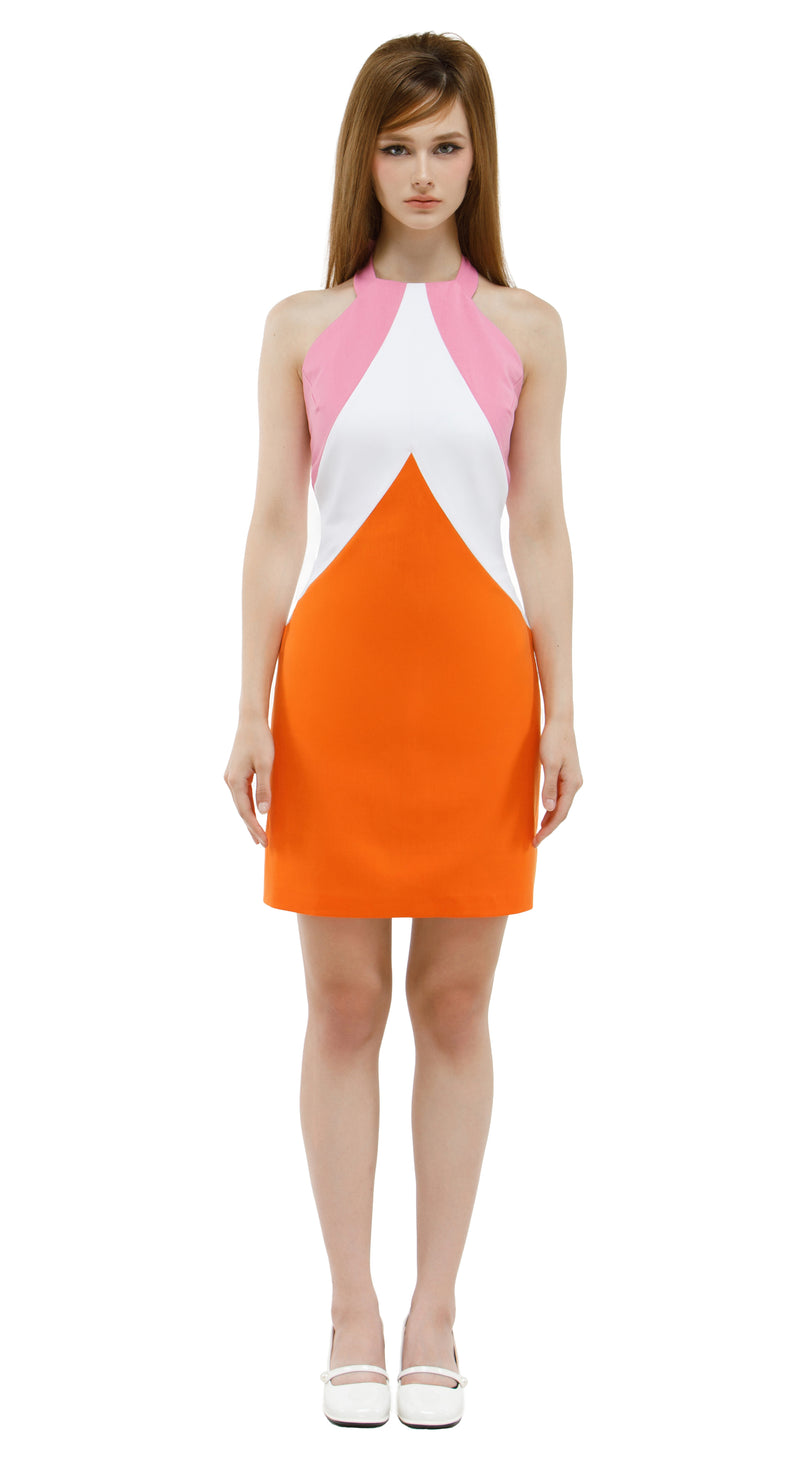 Woman wearing a mod 1960s style pink/white/orange chevron dress on a white background