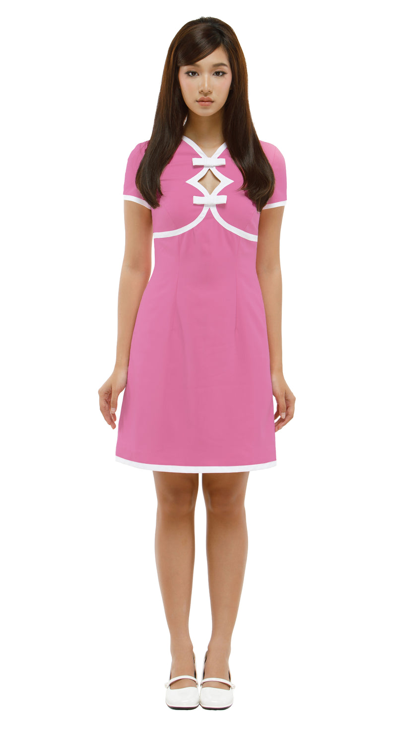Woman wearing a  Mod 1960s style pink dress with white accents, 2 diamond cutouts and 2 small bows on a white background