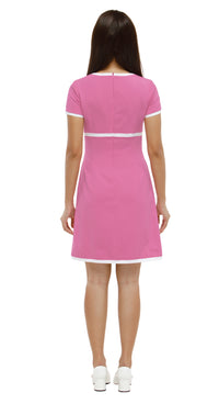 Woman wearing a  Mod 1960s style pink dress with white accents, 2 diamond cutouts and 2 small bows on a white background