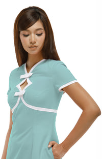 Woman wearing a  mint green, Mod 1960s style dress with white accents, 2 diamond cutouts and 2 small bows on a white background