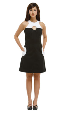 Woman wearing a black and white dress with cutout design on a white background