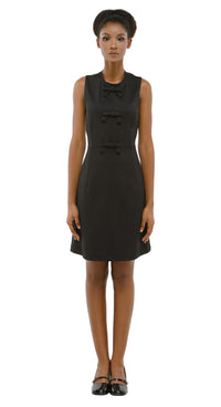 Black dress worn by a model on a white background