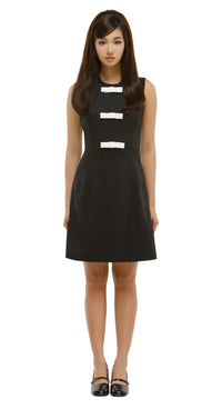 Woman wearing a black dress with white stripes on a white background