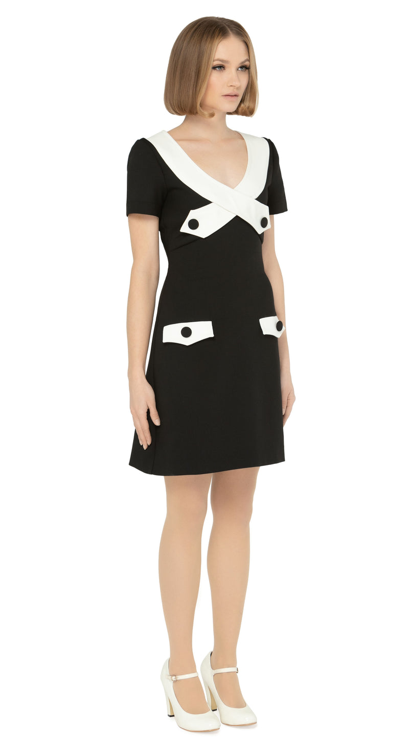 The contrasting dramatic white  neckline adds a touch of sophistication, while the imaginative creative detailing through decorative button placement and button-down essentials pockets makes for a very wearable and functional look. With a slight A-line skirt and short sleeves, this dress proves flattering on all figures.