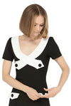 The contrasting dramatic white  neckline adds a touch of sophistication, while the imaginative creative detailing through decorative button placement and button-down essentials pockets makes for a very wearable and functional look. With a slight A-line skirt and short sleeves, this dress proves flattering on all figures.