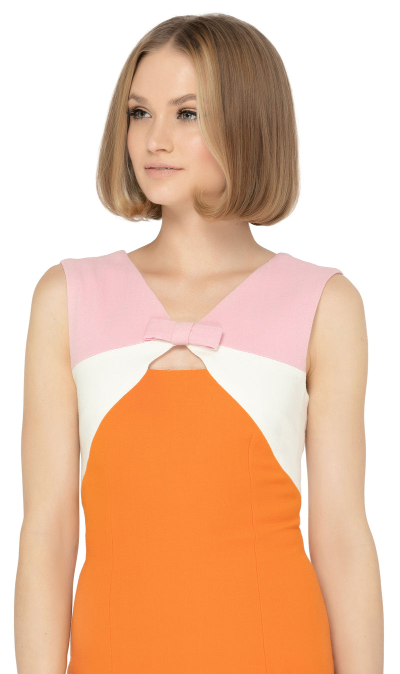 This gorgeous, sixties style dress is a perfect fit for springtime occasions. The fitted silhouette, sleeveless design, and structured pale pink shoulder panels lead to a white band and an orange body. The dress also features a feminine cutout with a dainty bow, and a v-neckline. Fully lined for comfort, this dress is sure to turn heads with its choice of flattering feminine details and easy to pair to color scheme.