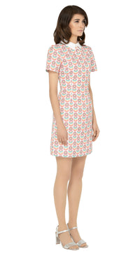 This classic, fitted sixties style spring floral fabric dress produced in a luxury French mill weave in white, peach, red, green, blue and yellow tones, with a classic stand up collar and short slightly puffed sleeves. It is designed with a zippered back closure for easy wear. The intricate detailing and exquisite craftsmanship make it a stunning piece. Perfect for a warm spring day, this dress is both stylish and comfortable.