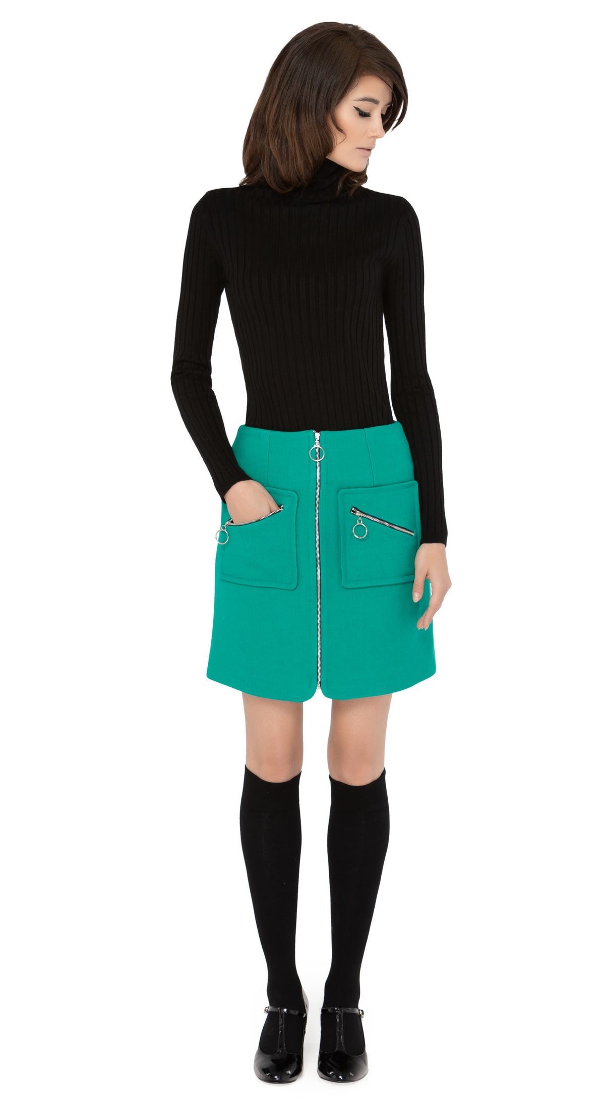 Marmalade zip up skirt in a stunning emerald green Italian wool blend, with functioning retro loop zip essentials pockets, and front retro loop zipper closure.  Shown here, worn with a classic black ribbed turtleneck and knee highs which are sold separately. Please inquire to shop the full look. Also available in classic black.  Pairs perfectly as intended with our 1960s Style Coat with Detachable Faux Fur.