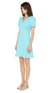 Stunning seventies style, Italian turquoise jersey, slightly flared dress with fitted torso and discreet hints of silver threading throughout the textured fabric. V-neckline, with three button detailing and slightly puffed short sleeves.  Choose bespoke for mid-length or long sleeves or an alternate hem length.